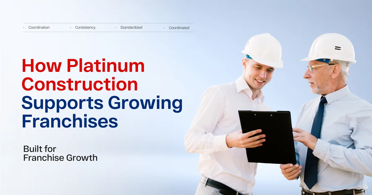 Two workers in white hard hats reviewing a clipboard together outdoors